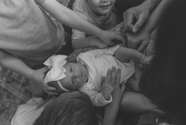 Family around their newborn sister.